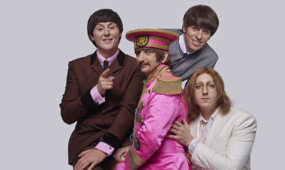 The Bootleg Beatles facing the camera and smiling