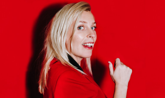 This image is of Sara Pascoe standing side-on and smiling