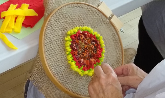 Student making a flower rag rug