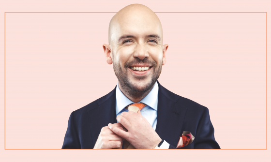 Tom Allen Laughing whilst holding his tie.