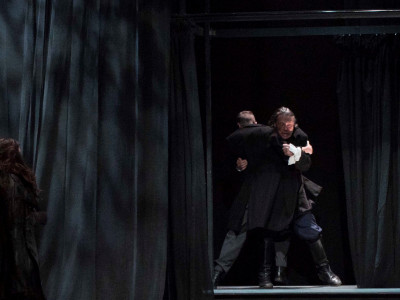 Two men wrestle on stage