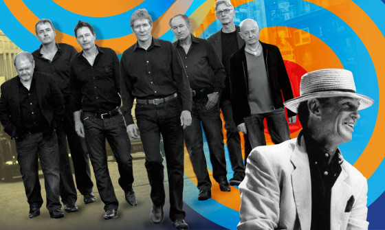 The Manfreds stand on an orange and blue swirl as they walk down the street.