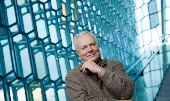 Yan Pascal Tortelier stands in front of windows. His hand is up to his chin