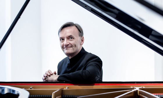 Stephen Hough is sat behind his piano smiling