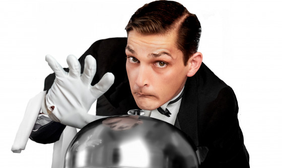A man dressed as a butler holds a tray in his hand