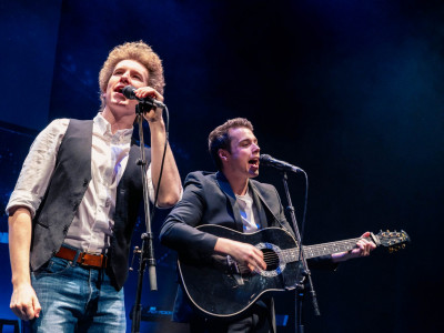 The Simon & Garfunkel Story sing into microphones