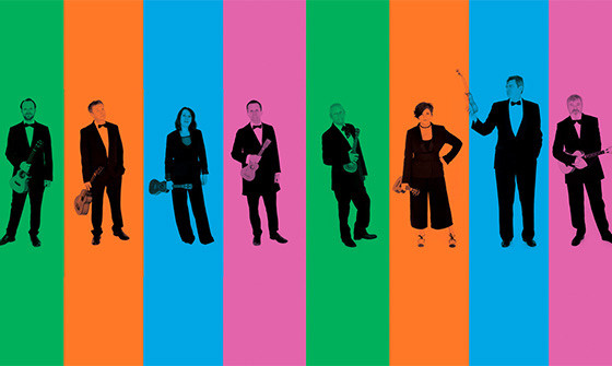 Eight players stand in a line holding their instruments