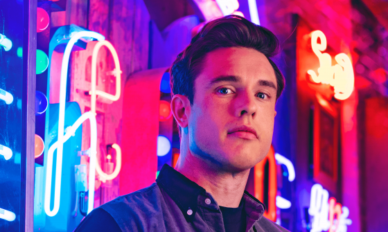 Ed Gamble stands in front of neon signs