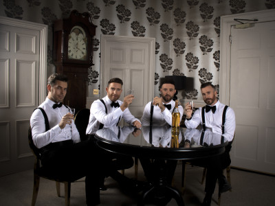 The Overtones sit at a table cheersing drinks