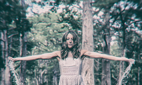 Carrie Elkin stands in a body of water splashing it with her hands