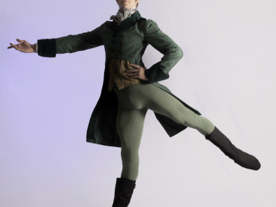 Willoughby strikes a pose, dressed in period dress, green and black.