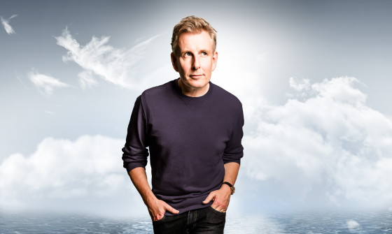Patrick Kielty stands on a map